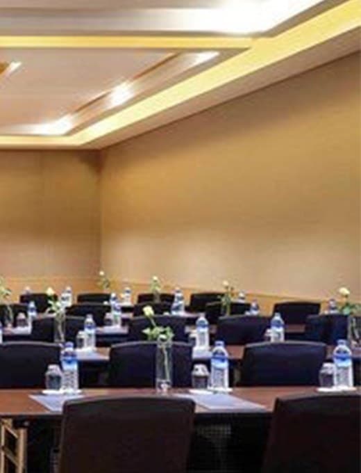 Meeting room set for a conference, with a projection screen at the front